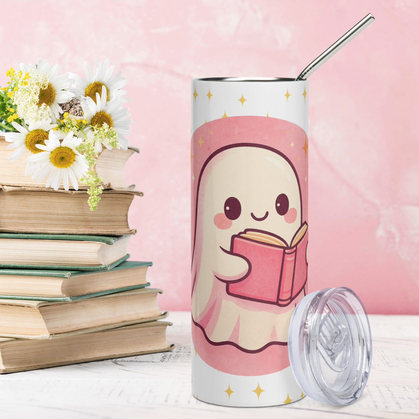 Front view of Pink Coquette Book Ghost Stainless Steel Tumbler on White Background. Bubblegum pink circle with white ghost with pink shadows and rosy cheeks. The ghost is holding a pink book that is open and is reading. In white text to the left Book and to the right Ghost. There are yellow stars in the background on the white. BPA free plastic lid is leaning on the right side of the water bottle. Bookish Gift for Book Clubs and BookTok