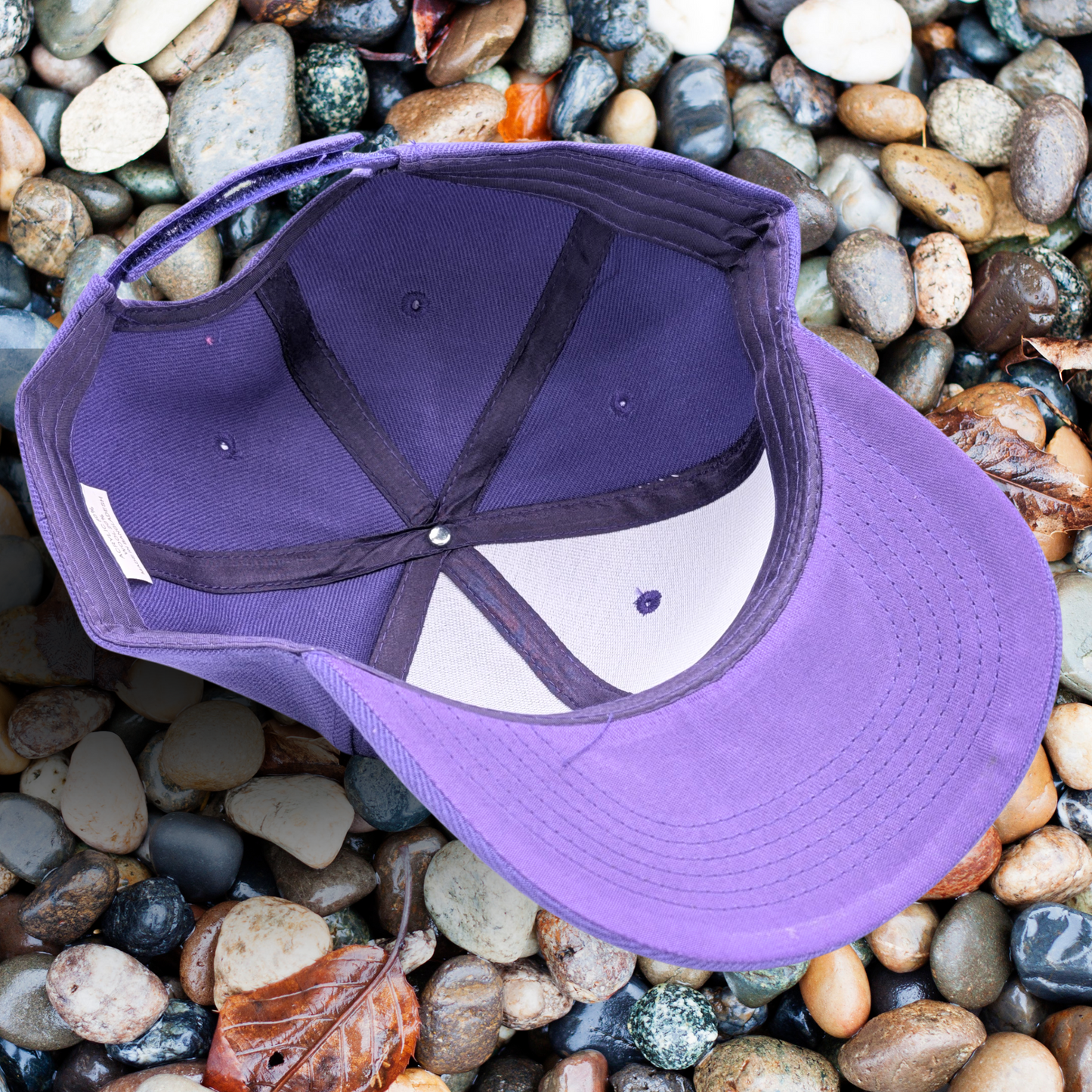 Bottom inside view of Purple Hat. Leather Laser Engraved Tan Patch on right side has a luna moth in front of a crescent moon.