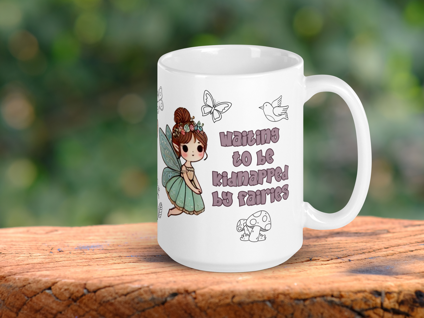 White Ceramic Mug handle to the right. This Fairy mug shows text in a dusky purple "Waiting to be kidnapped by fairies". Above to the right is the outline of a bird and to the left is the outline of a flower. Below the text is the outline of mushrooms. To the left is a flying fairy with blue butterfly wings. A blue dress, brunette hair in a un with flowers and pointed ears. Fantasy Bookish Mug Gift for Her