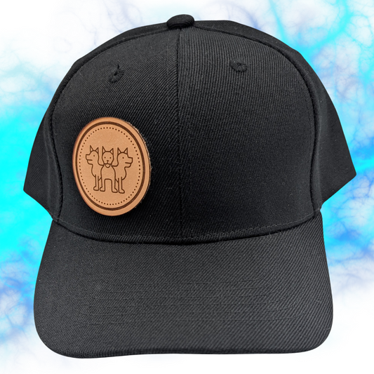 Front view Cerberus Leather Patch on left side of Black Hat. Laser engraved tan leather patch with a three headed Cerberus inside a circle. Three Headed Dog guardian of the underworld for Hades Roman Greek Mythology. Mythical Accessories Emporium