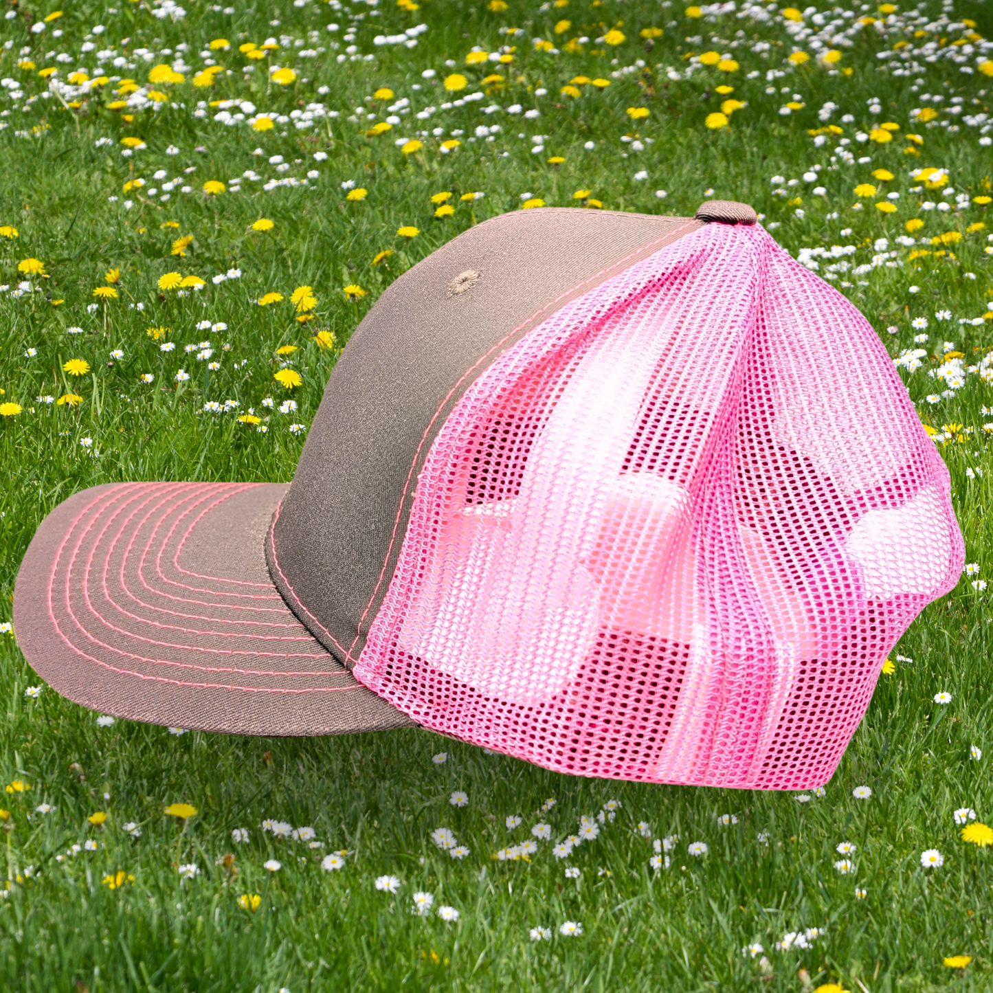 Snapback Trucker Hat with hot pink mesh and stitching. Bill and front of hat are medium gray. View of left side of hat.