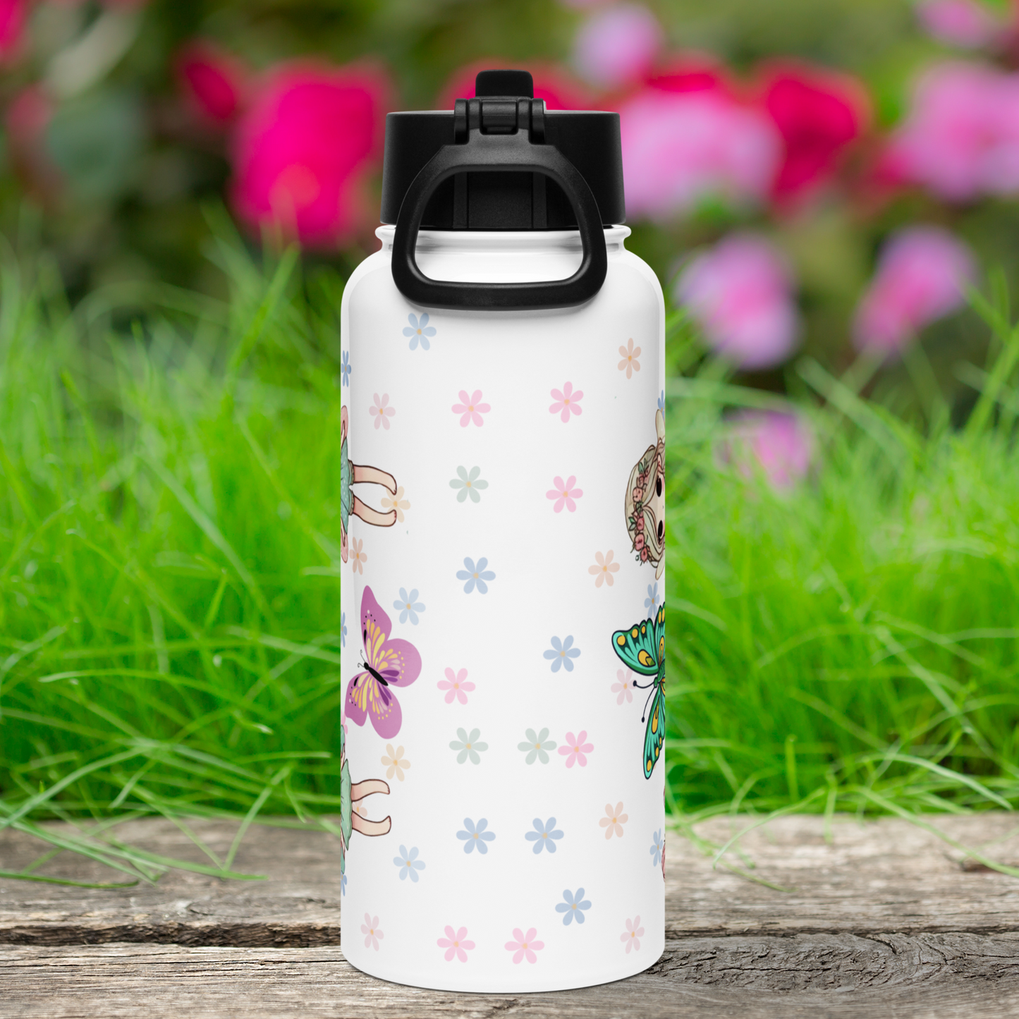 Back view of stainless steel 32 oz tumbler with black lid. You can see the background of pastel mini daisies. To the left you can see the feet of fairies and a pink butterfly. To the right you can see the top of a blue butterfly and the top of the blonde fairy's head.