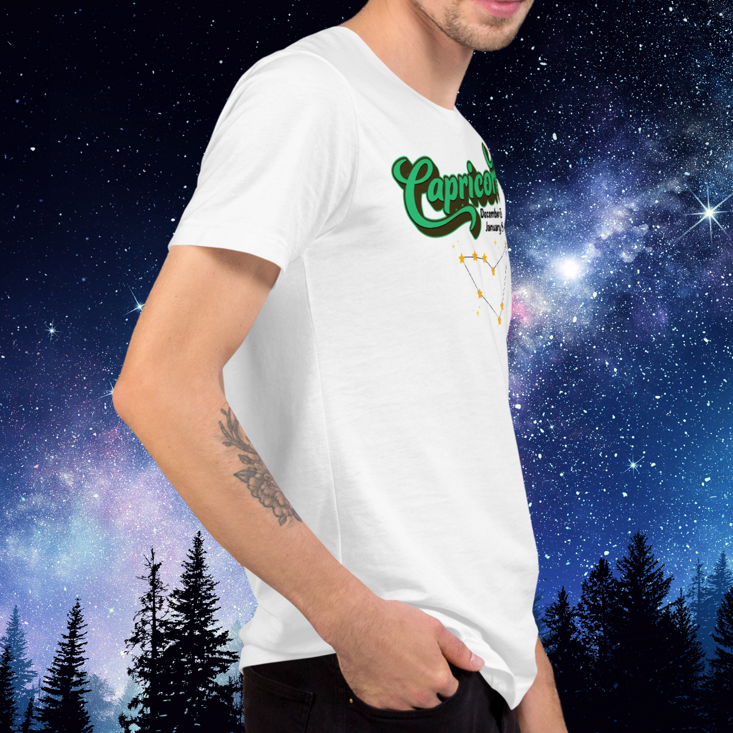 Right side view of model wearing white men's Capricorn Tee. You can see the side seam in the shirt. This astrology T-Shirt has the word Capricorn in large bright green script shadowed in deep brown almost black for a 3-D effect. Below this it Says December 22-January 19. Under Capricorn is the zodiac star constellation with yellow stars connected by a black line and lighter yellow smaller stars surrounding this. The perfect December or January Birthday Gift for him or yourself.