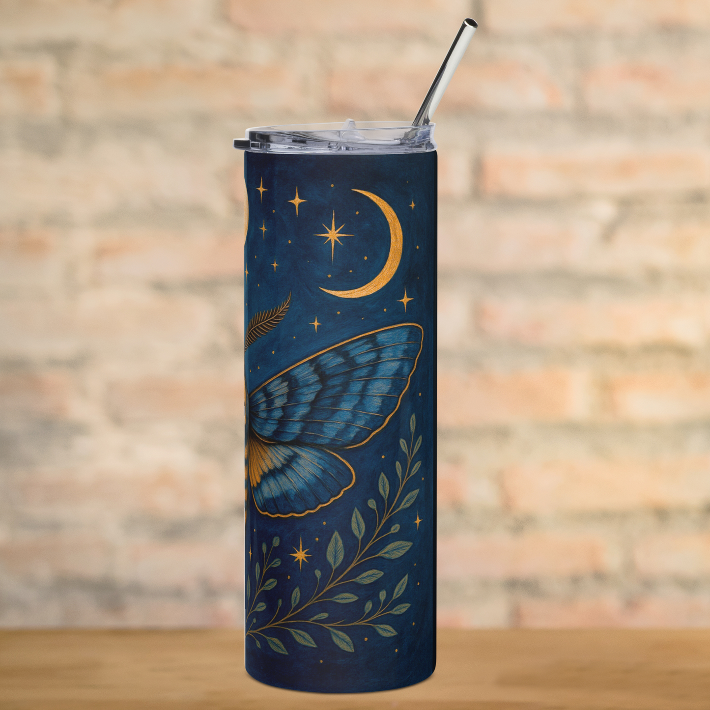 Death Head Moth Tumbler Stainless Steel 20 oz. View of right side wing. Below the moth are spreading green branches and stars. Above the moth is the waxing crescent moon. Metal straw can be seen above the edges of the lid. Fantasy Celestial Moth Tumbler