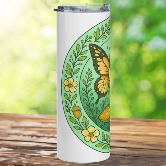 Fairy Circle Stainless Steel 20 oz Tumbler left side view. On this side you see the border of vines, flowers, and acorns. One butterfly wing is visible and part of the mushroom the fairy sits on. Fantasy Book Lover's Gift