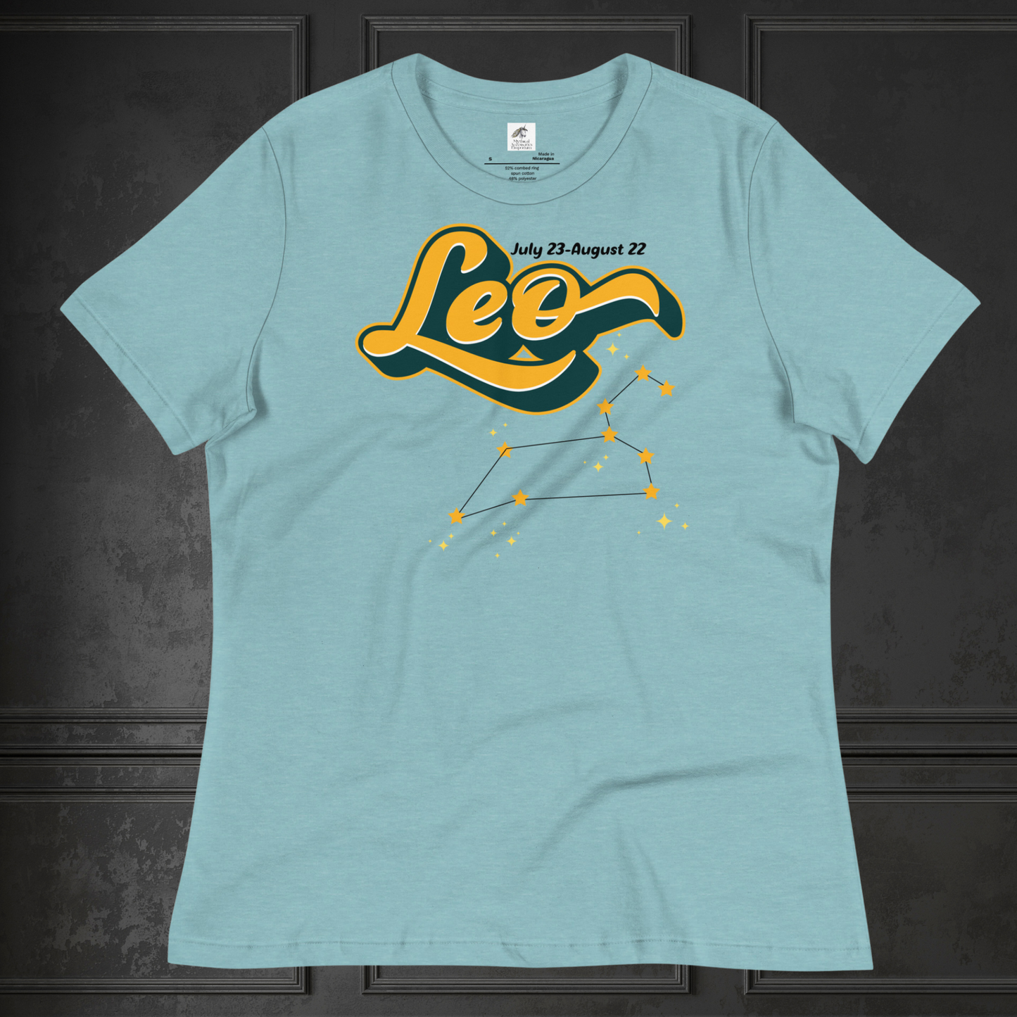 Front view of heather blue lagoon flat lay women's Leo Tee. This astrology Leo T-Shirt has the word Leo in large yellow script shadowed in deep green for a 3-D effect. Above this it Says July 23-August 22. Under Cancer is the zodiac star constellation with yellow stars connected by a black line and lighter yellow smaller stars surrounding this. The perfect July or August Birthday Gift for Her or yourself.