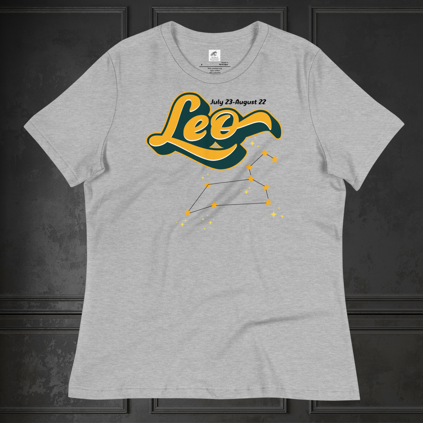 Front view of flat lay athletic heather grey women's Leo Tee. This astrology Leo T-Shirt has the word Leo in large yellow script shadowed in deep green for a 3-D effect. Above this it Says July 23-August 22. Under Cancer is the zodiac star constellation with yellow stars connected by a black line and lighter yellow smaller stars surrounding this. The perfect July or August Birthday Gift for Her or yourself.