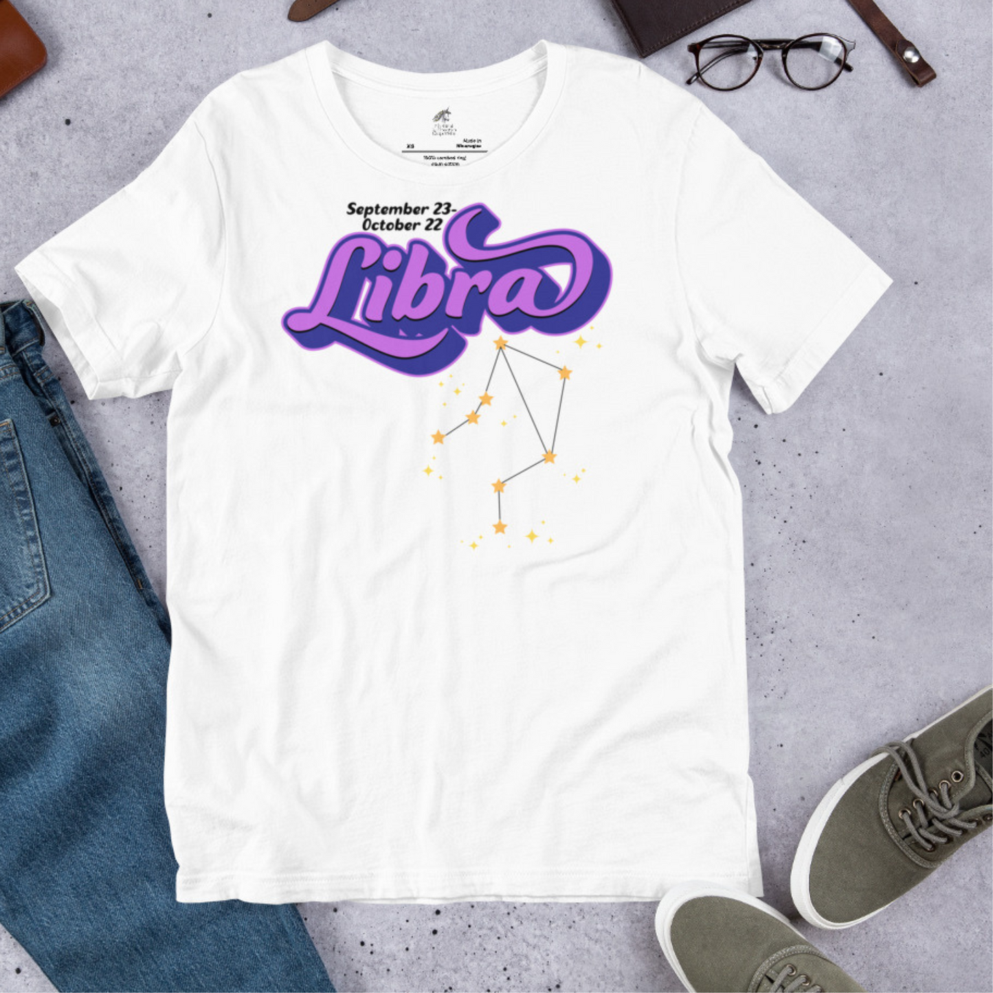 Flat front view of white men's Libra Tee. This astrology Libra T-Shirt has the word Libra in large purple script shadowed in deep blue for a 3-D effect. Below this it Says September 23-October 22. Under Libra is the zodiac star constellation with yellow stars connected by a black line and lighter yellow smaller stars surrounding this. The perfect October or September Birthday Gift for him or yourself.
