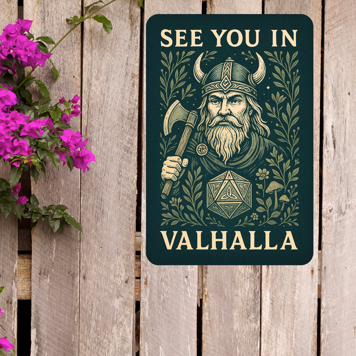 Metal Wall Poster 8x12 hanging on a wood fence next to a basket of flowers. Dark green Metal Sign with graphic in light golden browns. Bearded Viking wearing a horned helmet and holding an axe over his shoulder. D20 with symbols instead of numbers below the Viking. Botanical Design surrounding the image with mushrooms, vines, and flowers. At the top of the wall art it says, "See You In". At the bottom of the home decor, "Valhalla". Warhammer Role Playing Game