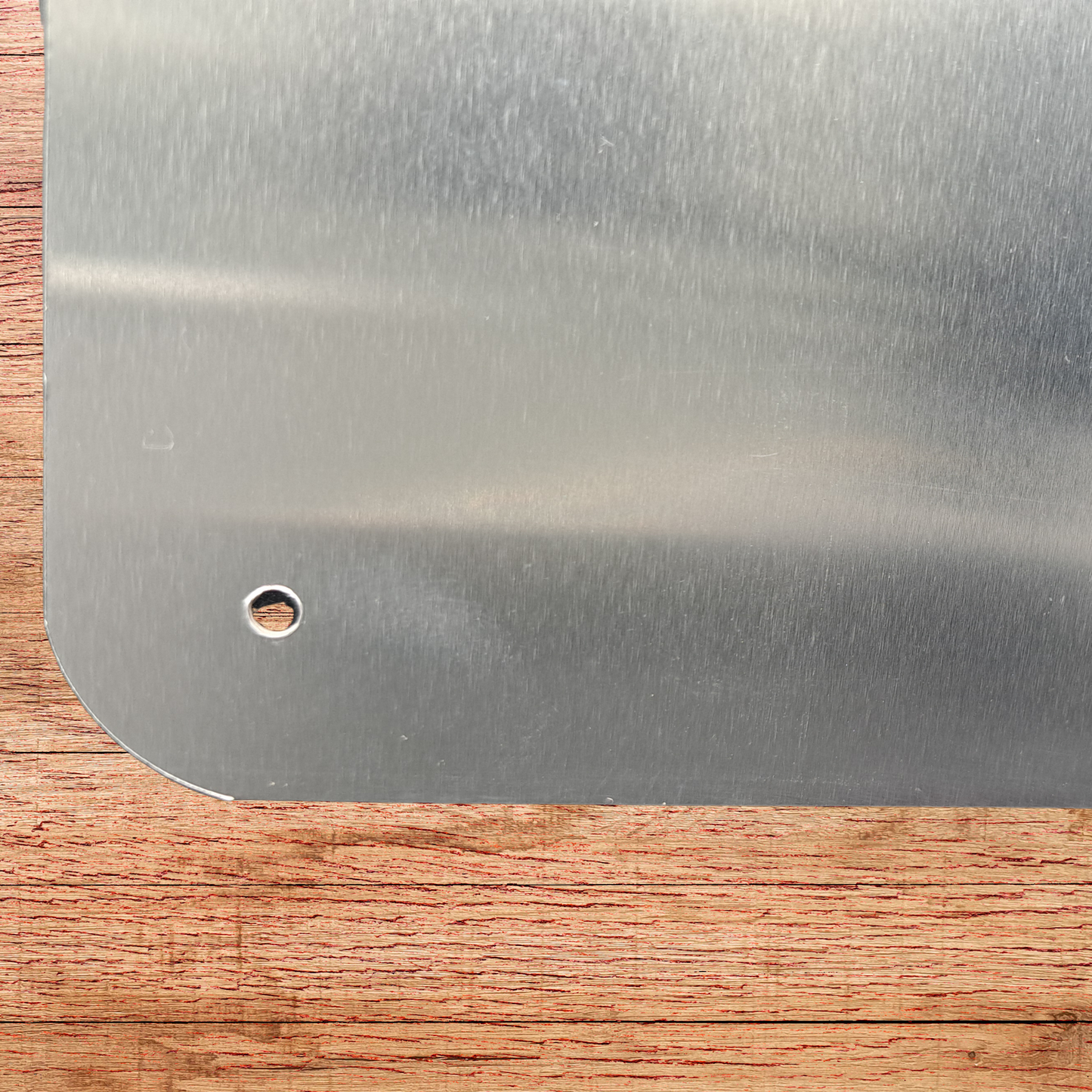 Back of metal sign showing the lower left corner is rounded and has a hole. This is to illustrate that every corner is rounded and has a hole for hanging.