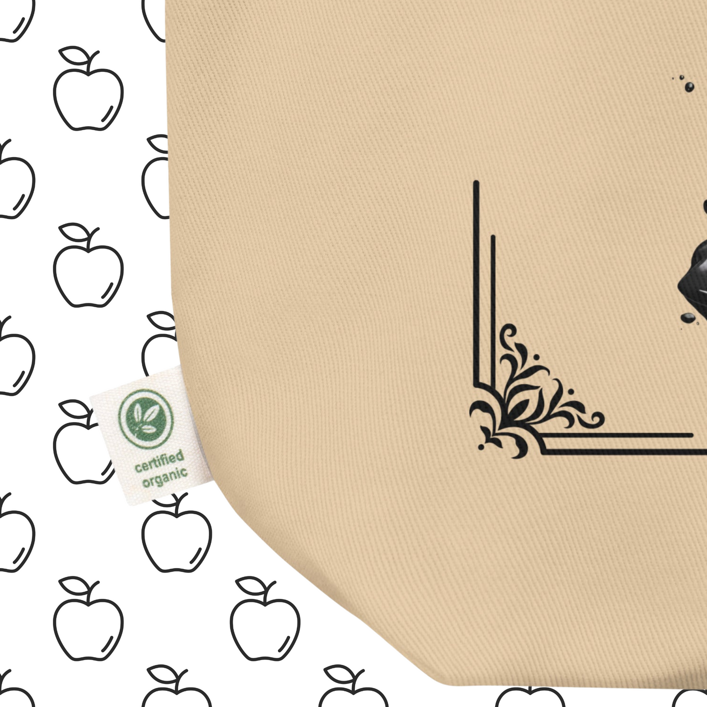 Up close view of front bottom left corner to see certified organic tag Natural Organic Tote Bag Poisoned Apple Enthusiast above a decaying apple sitting in a pool of poison