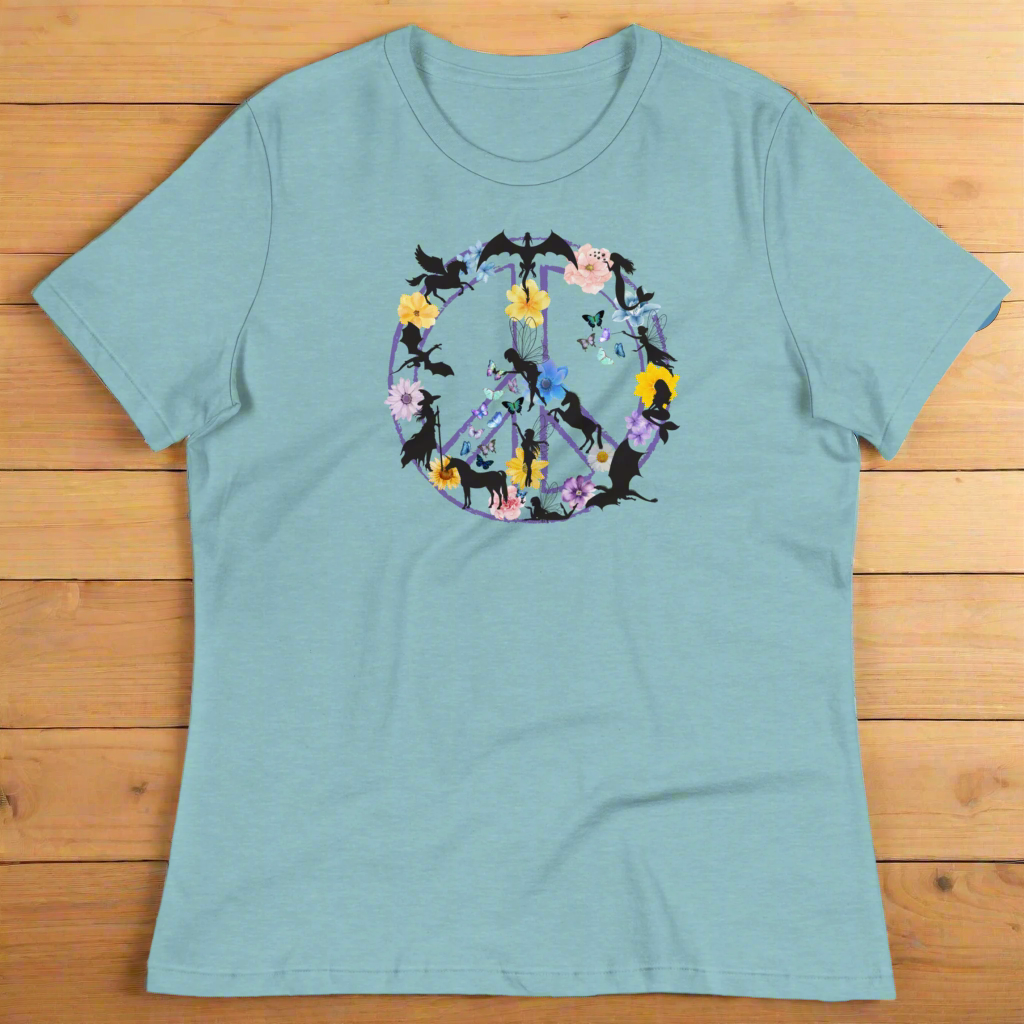 70s Vintage Peace Sign Women's heather blue lagoon T-Shirt Front View on wooden counter. Purple Peace sign filled in with dragons, mermaids, fairies, unicorns, pegasi, witches, flowers, and butterflies.
