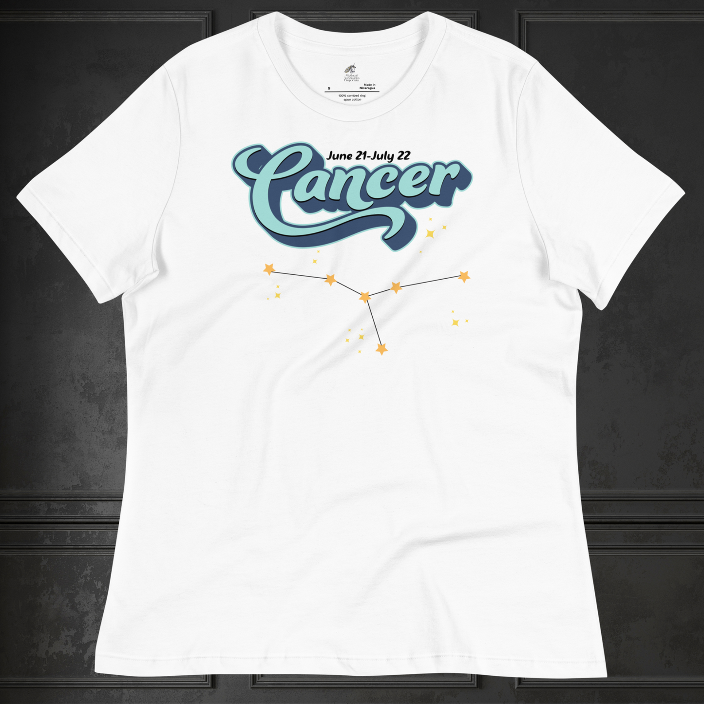 Front view of flat lay white astrology women's Cancer Tee. This astrology Cancer T-Shirt has the word Cancer in large light blue script shadowed in deep blue for a 3-D effect. Above this it Says June 21-July 22. Under Cancer is the zodiac star constellation with yellow stars connected by a black line and lighter yellow smaller stars surrounding this. The perfect June or July Birthday Gift for Her or yourself.