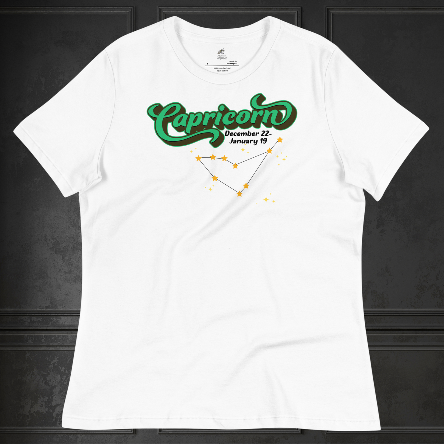 Front view of flat white women's Capricorn Tee. This astrology T-Shirt has the word Capricorn in a large green script shadowed in black for a 3-D effect. Below this it Says December 22-January 19. Under Capricorn is the zodiac star constellation with yellow stars connected by a black line and lighter yellow smaller stars surrounding this. The perfect December or January Birthday Gift for Her or yourself.