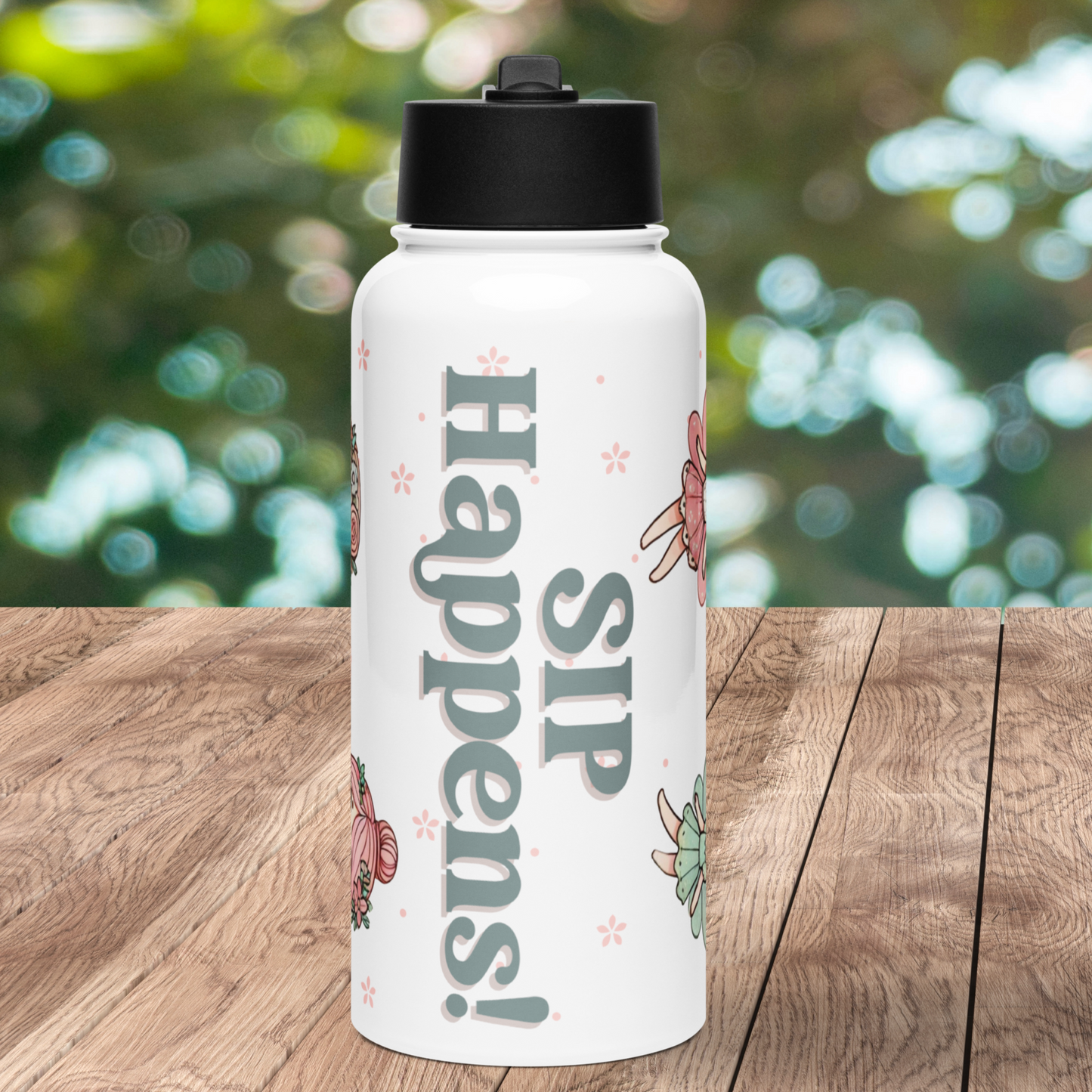 Front view of white stainless steel water bottle with black plastic lid. Text Sip Happens! in Grey Blue. In the background you can see light pink flower shapes