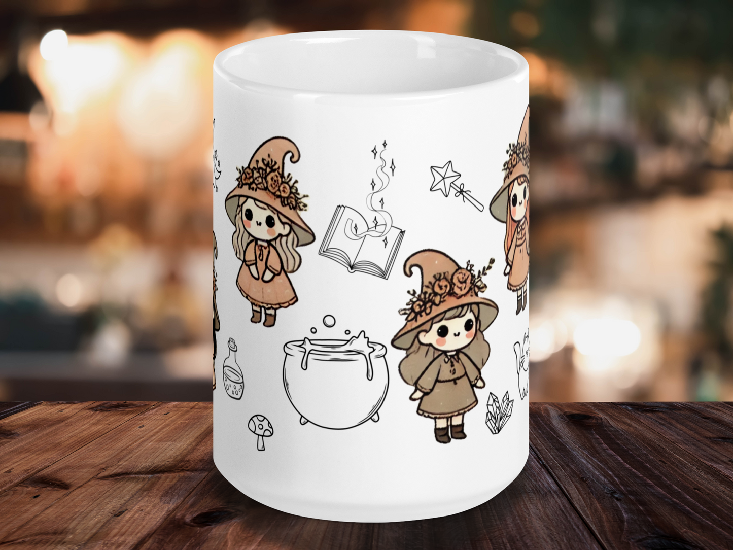Vintage Witch mug, ceramic white mug with handle to the back. Three little vintage witches are visible in earth tone dresses and witch hats. The hats have flowers around them. Around the witches are black outlines of a spell book, a cauldron, crystals, a magic wand, a potion bottle, and a mushroom.