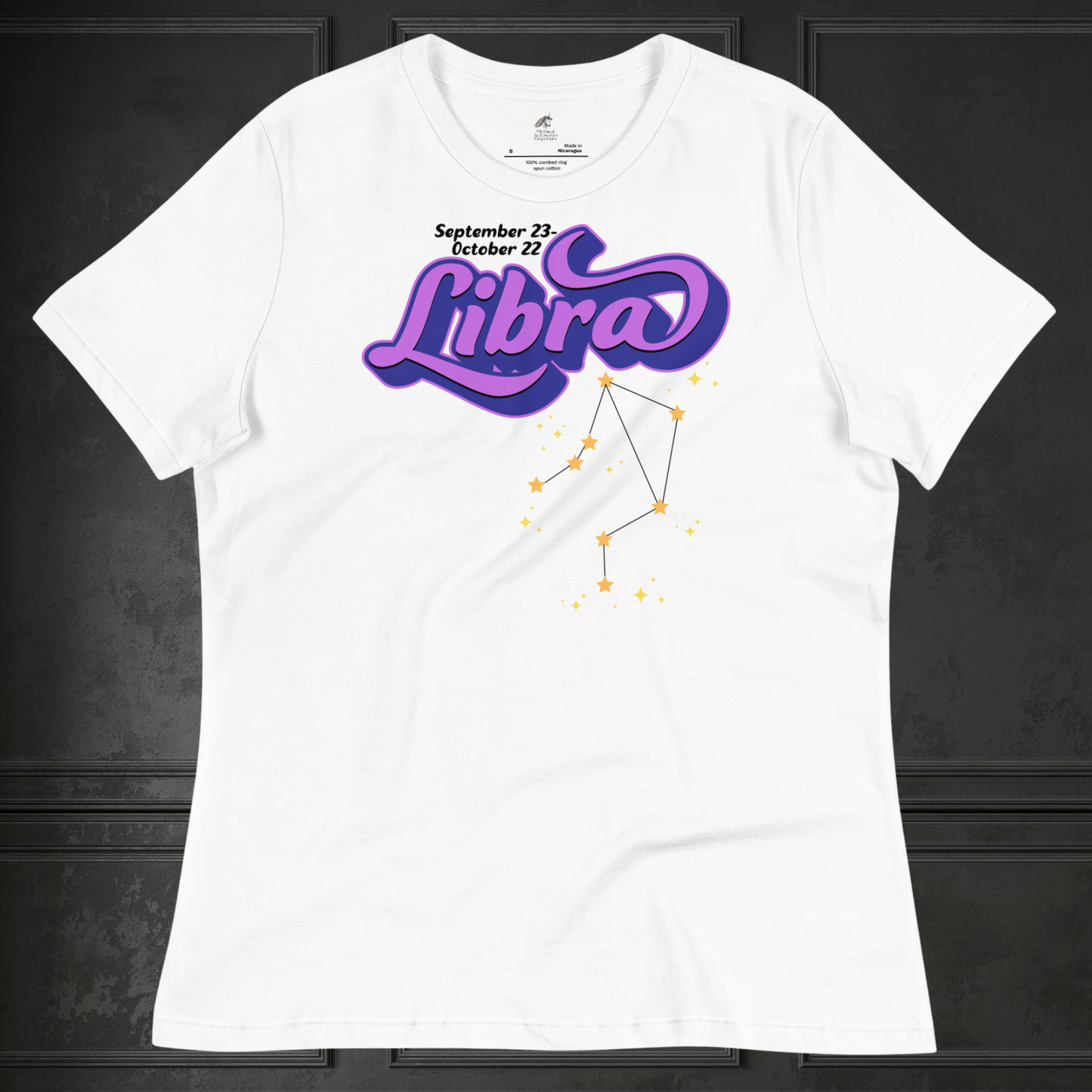 Front view of flat white astrology women's Libra Tee. This astrology Libra T-Shirt has the word Libra in large purple script shadowed in deep blue for a 3-D effect. Below this it Says September 23-October 22. Under Libra is the zodiac star constellation with yellow stars connected by a black line and lighter yellow smaller stars surrounding this. The perfect October or September Birthday Gift for Her or yourself.