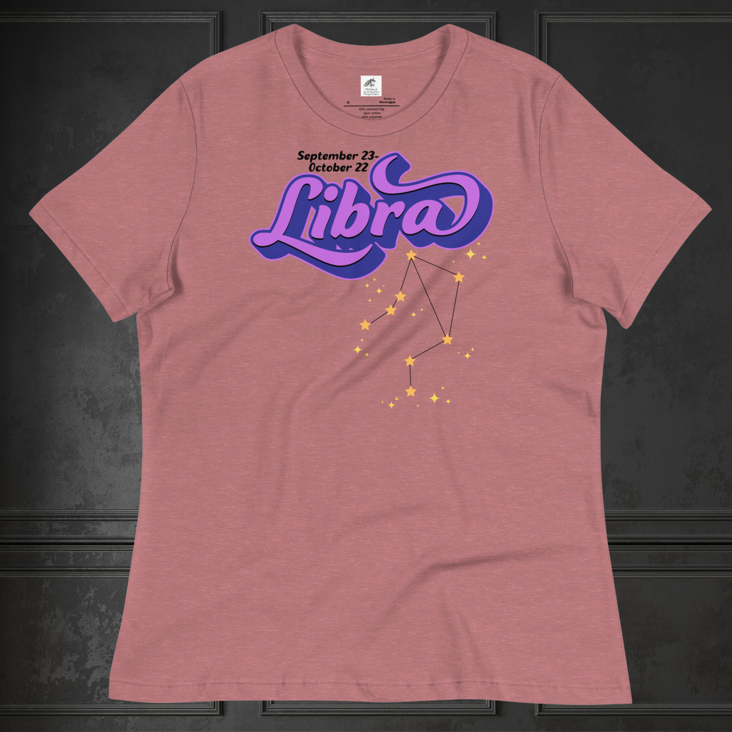 Front view of flat heather mauve women's Libra Tee. This astrology Libra T-Shirt has the word Libra in large purple script shadowed in deep blue for a 3-D effect. Below this it Says September 23-October 22. Under Libra is the zodiac star constellation with yellow stars connected by a black line and lighter yellow smaller stars surrounding this. The perfect October or September Birthday Gift for Her or yourself.