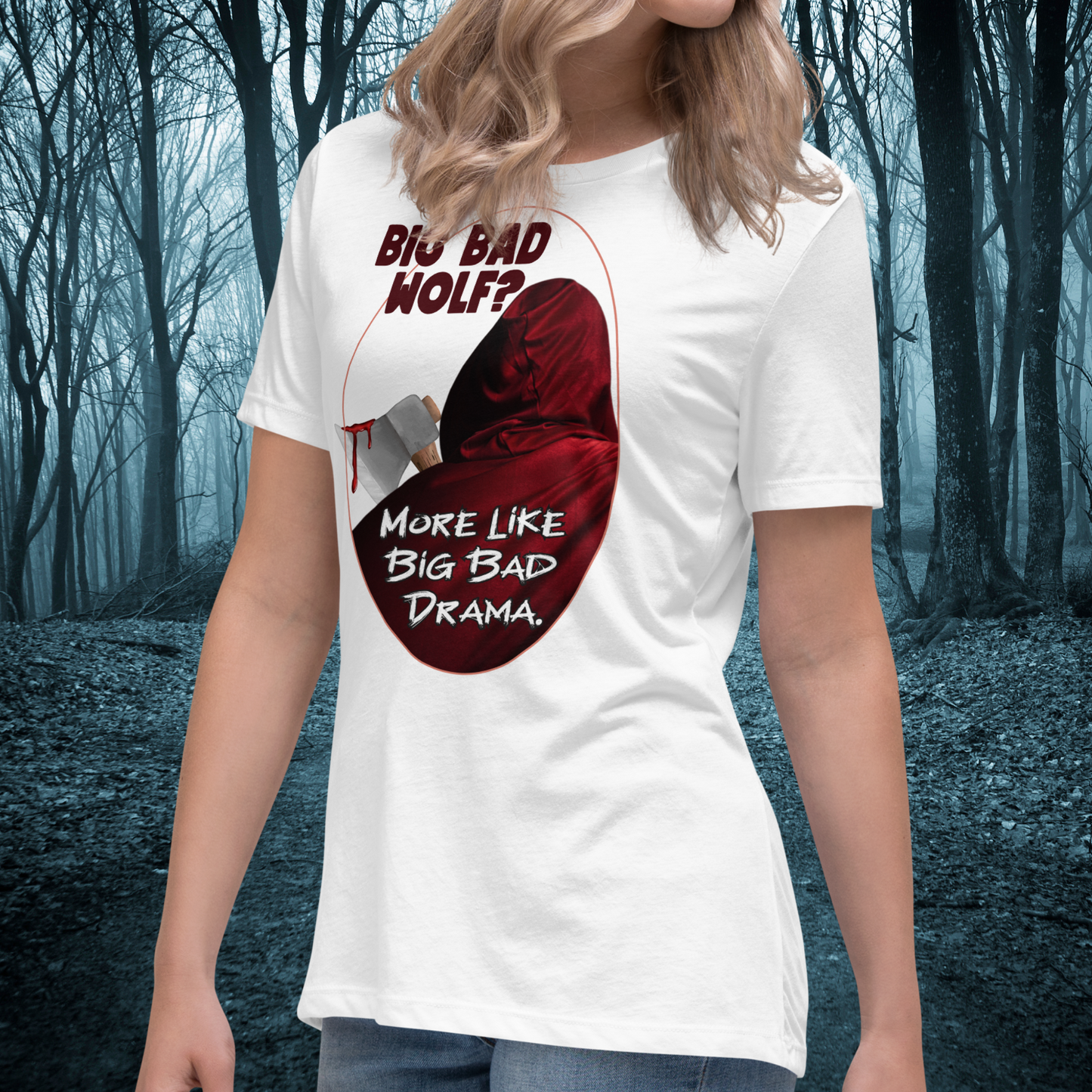 Red Riding Hood Women's Dark Fantasy T-Shirt. Front right View White Graphic Tee on Model. Oval frame with thin red border. You can see the back of red riding hood with hood up. Bloody axe over her shoulder. Text Big Bad Wolf? More Like Big Bad Drama. Dark Romantasy book lovers tee
