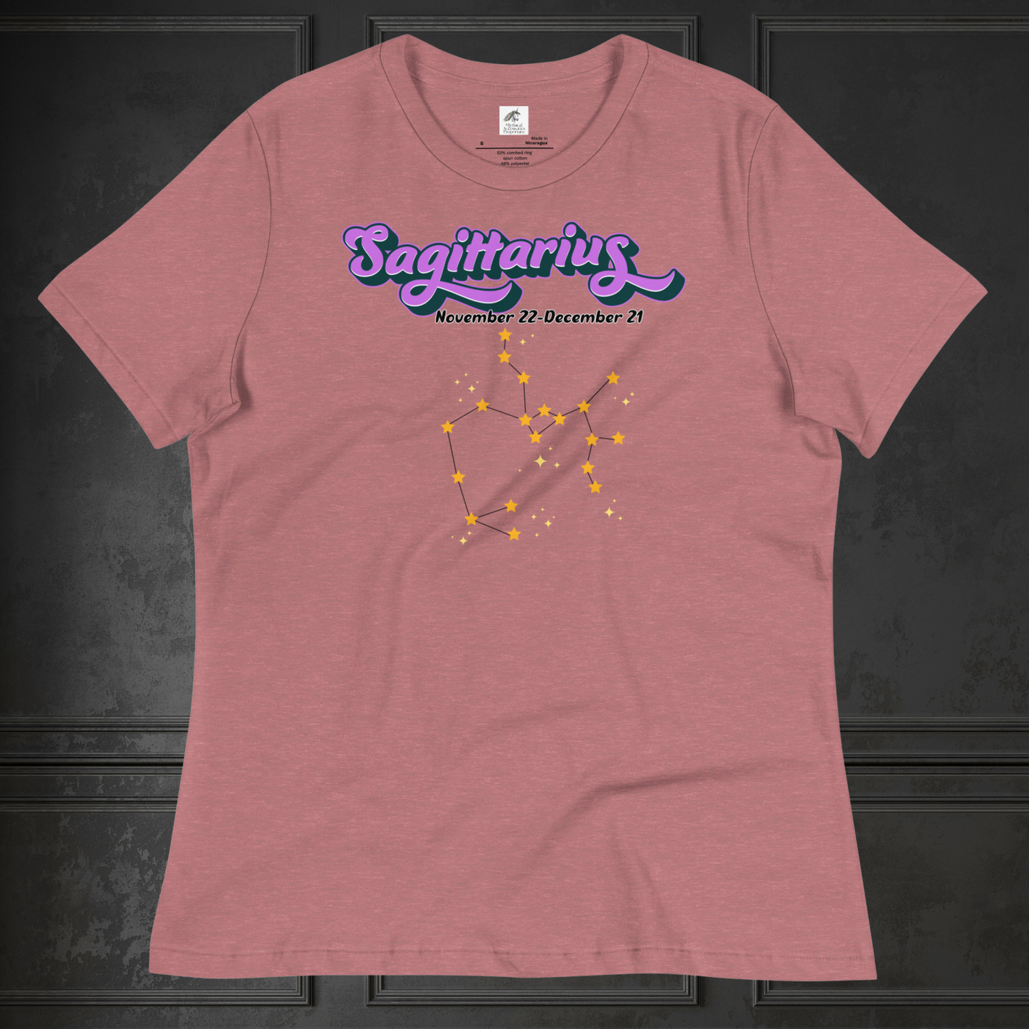 Front view of flat heather mauve (light red) women's Sagittarius Tee. This astrology T-Shirt has the word Sagittarius in large purple script shadowed in black for a 3-D effect. Below this it Says November 22-December 21. Under Sagittarius is the zodiac star constellation with yellow stars connected by a black line and lighter yellow smaller stars surrounding this. The perfect November or December Birthday Gift for her or yourself.