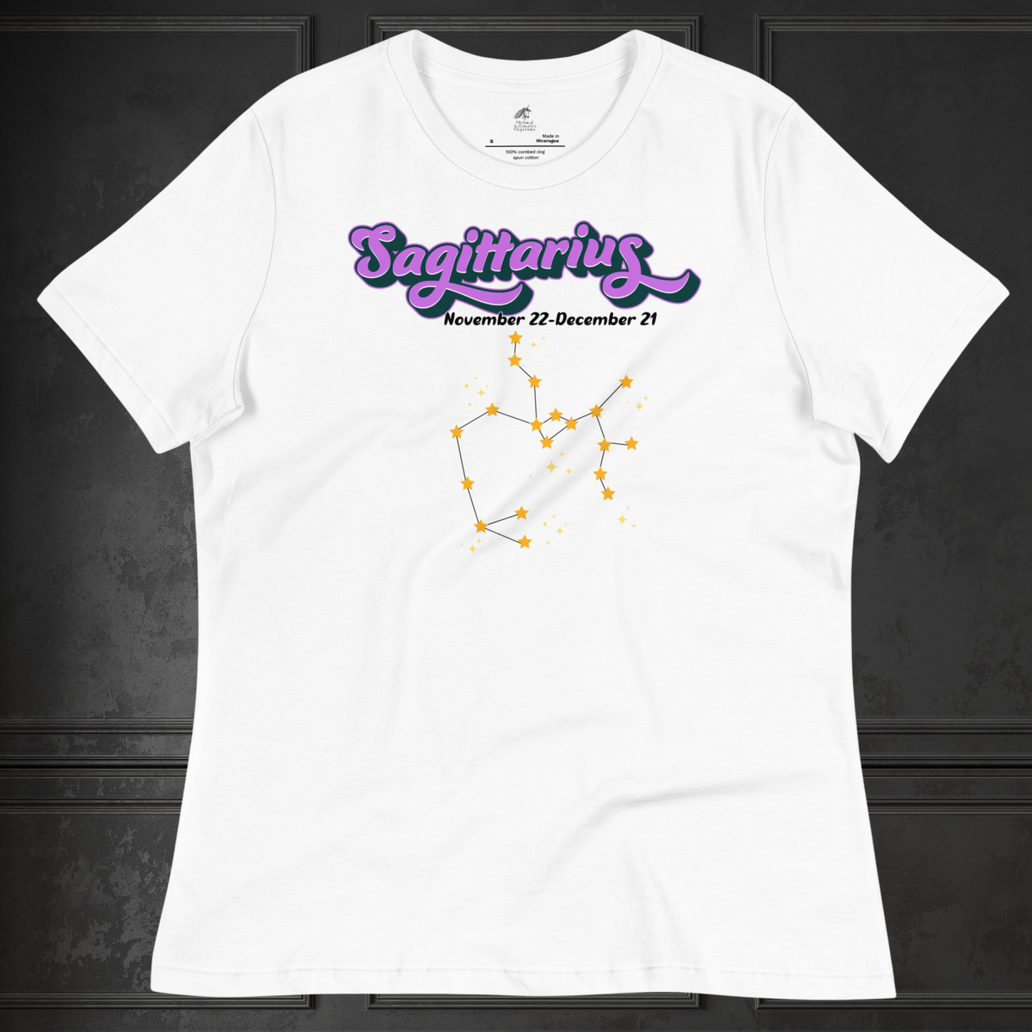 Front view of flat white women's Sagittarius Tee. This astrology T-Shirt has the word Sagittarius in large purple script shadowed in black for a 3-D effect. Below this it Says November 22-December 21. Under Sagittarius is the zodiac star constellation with yellow stars connected by a black line and lighter yellow smaller stars surrounding this. The perfect November or December Birthday Gift for her or yourself.