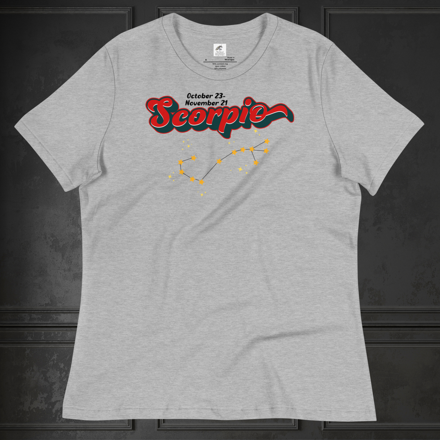 Front view of flat athletic heather (grey) women's Scorpio Tee. This astrology Scorpio T-Shirt has the word Scorpio in large red script shadowed in deep dark blue for a 3-D effect. Above this it Says October 23-November 21st. Under Scorpio is the zodiac star constellation with yellow stars connected by a black line and lighter yellow smaller stars surrounding this. The perfect October or November Birthday Gift for her or yourself.