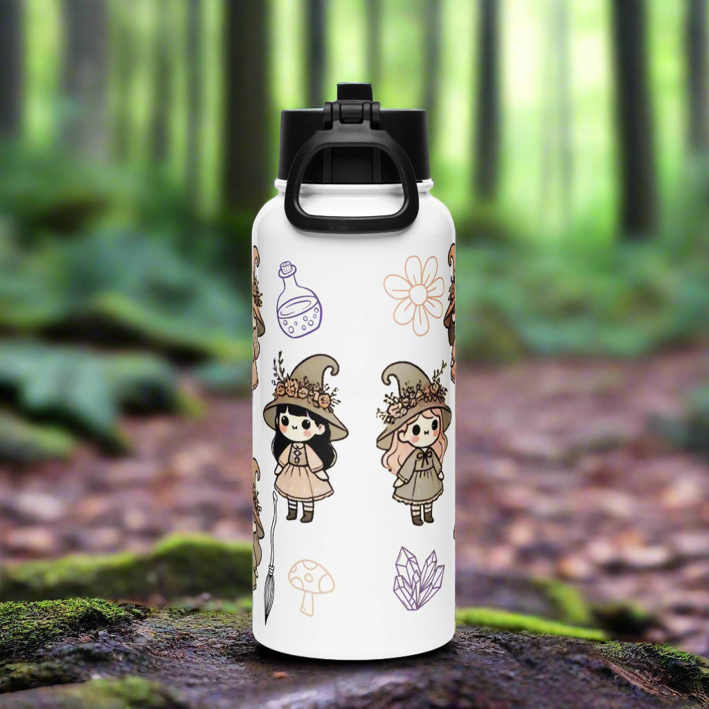 Back of white water bottle. Black lid with handle flipped down. Outline of potion bottle, flower, mushroom, and crystals. 2 Adorable witches in a hand drawn vintage style. Both wearing long dresses, boots, and witch hats with flowers. One with black hair and one with red hair.