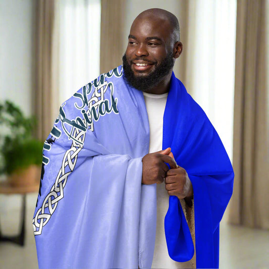 My Spirit Animal Raven Crow Sherpa Blanket. Blanket shown over the shoulders of a man. Raven wings spread as he soars inside a white Celtic Knot circle frame, My Spirit Animal bisects the lower right side of the circle. Background of blanket is a dip dyed deep violet blue. Darker at the top with a graduated color to the lighter bottom. Mythical Accessories Emporium. the crow shirt, Morrigan, Celtic Mythology, Odin's Ravens, WIccan