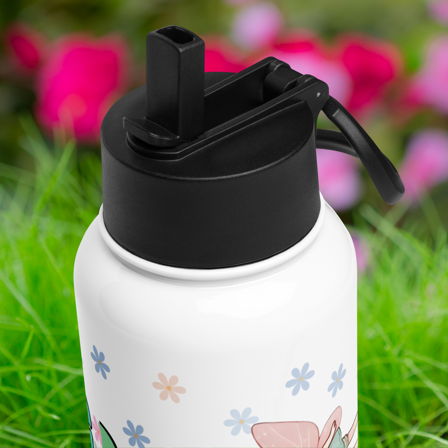 Top view of the plastic black lid on the tumbler. You see the drinking straw is flipped up and the channel it flips down into is visible.