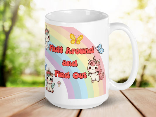 Sarcastic Unicorn Pegasus Rainbow ceramic 15 oz white mug. Kawaii Mug handle to the right. Rainbow is visible. Yellow butterfly above text and blue butterfly to the right of the text. Pink bubble letters "Fluff Around and Find Out" with a black outline. To the right bottom is a unicorn standing up with pink hair and mane. Flowers in the mane. To the left bottom is a unicorn pegasus sitting down with blue wings and mane. Pink flowers in mane. To the top left you can see the head of a flying unicorn pegasus.