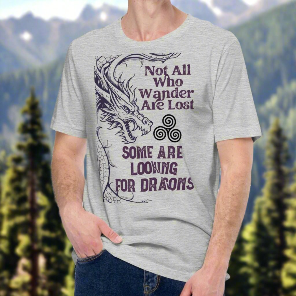 athletic heather (grey) men’s T-shirt, front view. Right side features a dragon in smoky gray-purple with the Celtic triskele symbol emerging from its nostrils. Text above reads "Not All Who Wander Are Lost," with "Some Are Looking for Dragons" below.