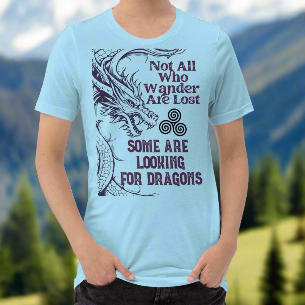 ocean blue men’s T-shirt, front view. Right side features a dragon in smoky gray-purple with the Celtic triskele symbol emerging from its nostrils. Text above reads "Not All Who Wander Are Lost," with "Some Are Looking for Dragons" below.