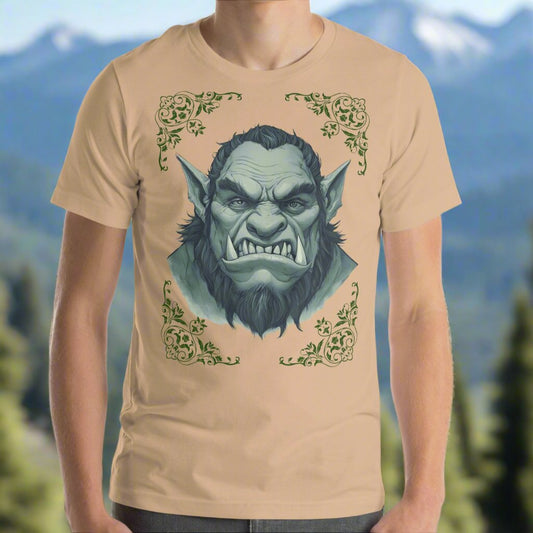 Front view of Men's Tan Graphic Tee with a black and white orc on the front. The orcs lower canines jut up as tusks over his top lip. He has a bulbous nose, eyebrows drawn down into a fierce expression, a large forehead, large pointed ears, his hair is black and pulled back with a widows peak, he has hair down the sides of his face and a medium sized beard. Framing the orc in four corners is 1920s retro floral border in dark green. This is a regular fit men's tshirt or a unisex shirt.