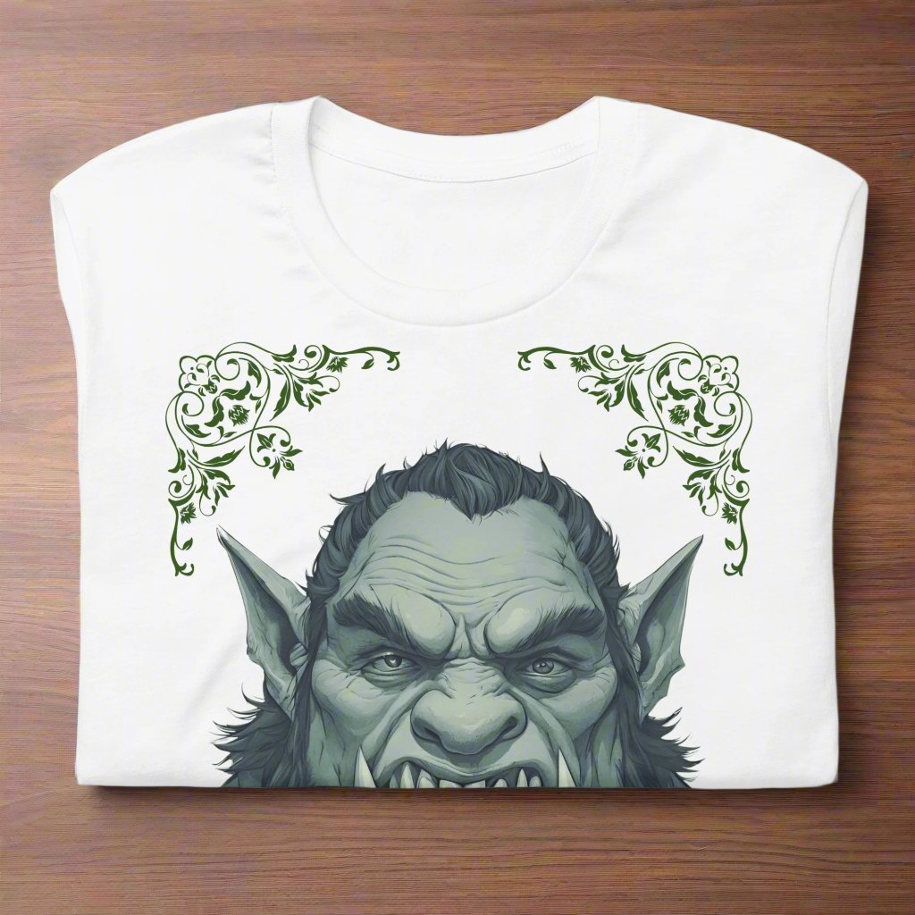 Front view of flat folded Men's white Graphic Tee with a black and white orc on the front. The orcs lower canines jut up as tusks over his top lip. He has a bulbous nose, eyebrows drawn down into a fierce expression, a large forehead, large pointed ears, his hair is black and pulled back with a widows peak, he has hair down the sides of his face and a medium sized beard. Framing the orc in four corners is 1920s retro floral border in dark green. This is a regular fit men's tshirt or a unisex shirt.