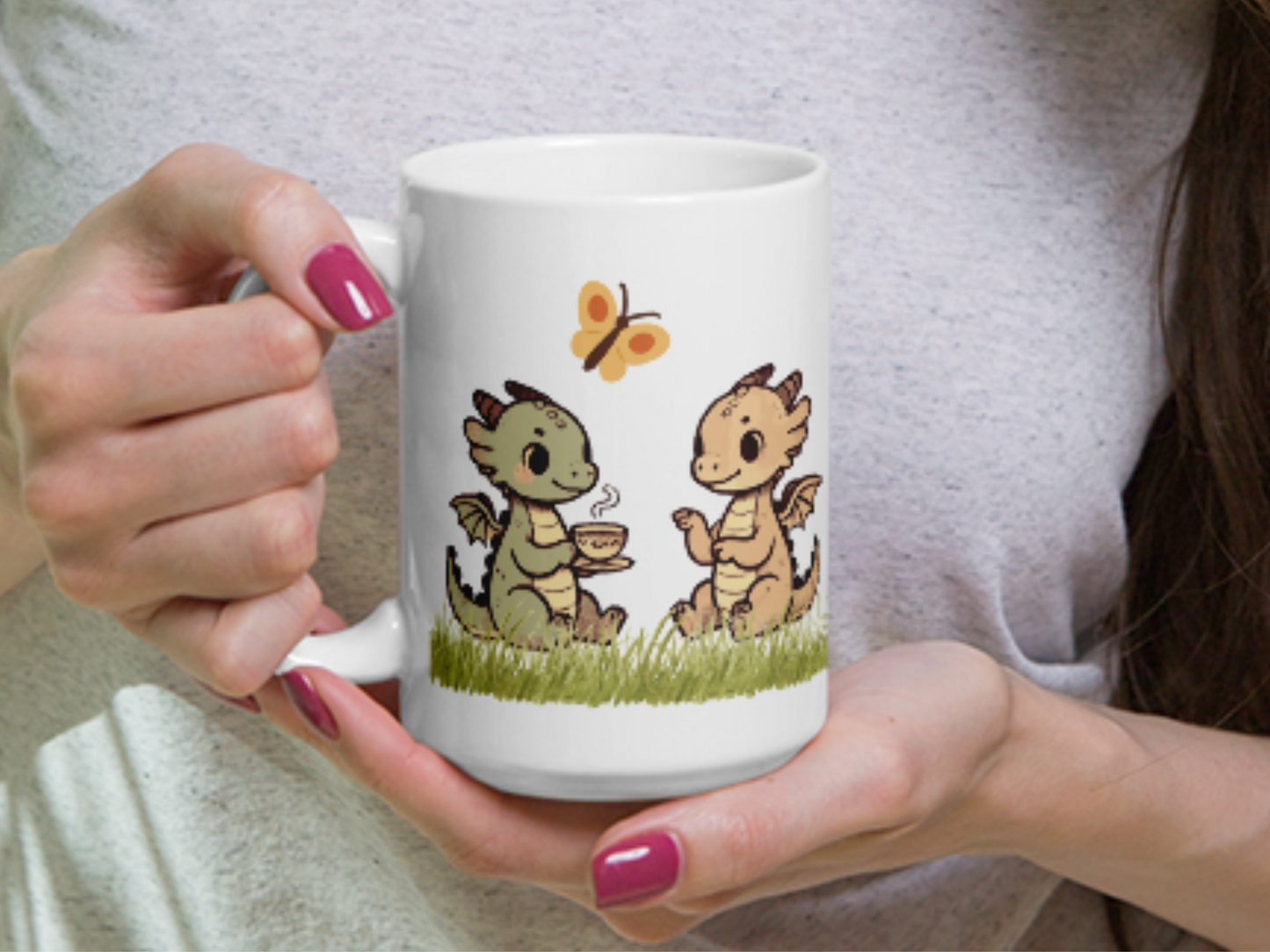 Woman holding dragon tea mug in her hands. Handle is to the left and you can see the two dragons having tea in the grass.