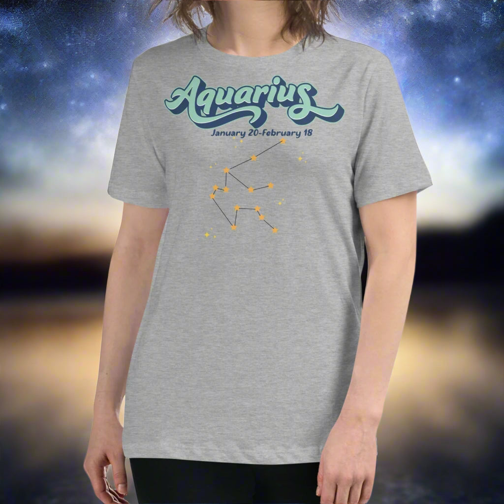 Woman in a athletic heather astrology Aquarius T-shirt facing forward. At the top in light blue is the word Aquarius outlined in deeper blue. Below this it says January 20- February 18. Under this is the Aquarius constellation with orange yellow stars connected by a black line. Astrology Zodiac Aquarius Woman's Tee