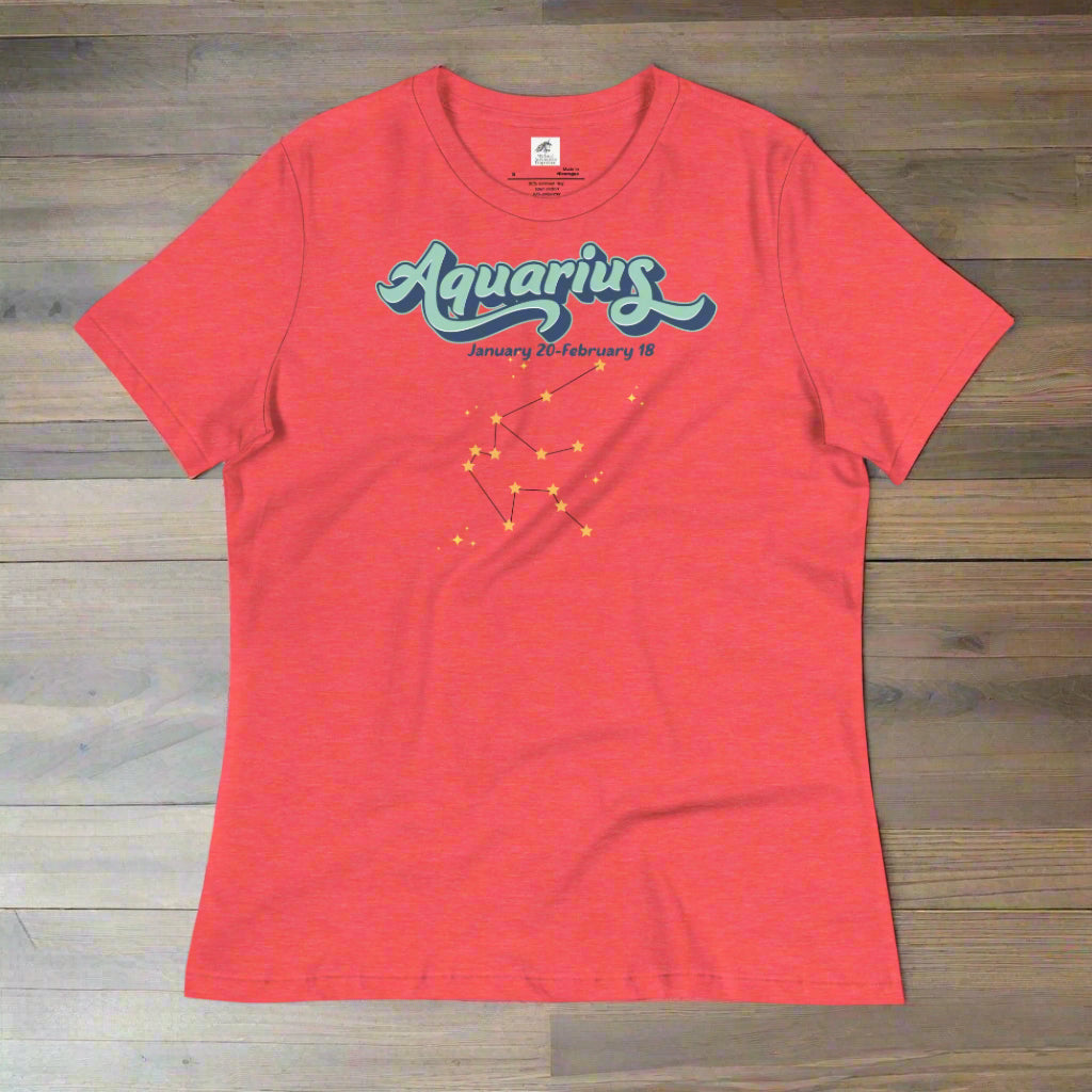 Flat lay heather red astrology Aquarius women's T-shirt on a wooden counter. At the top in light blue is the word Aquarius outlined in deeper blue. Below this it says January 20- February 18. Under this is the Aquarius constellation with orange yellow stars connected by a black line. Astrology Zodiac Aquarius Woman's Tee