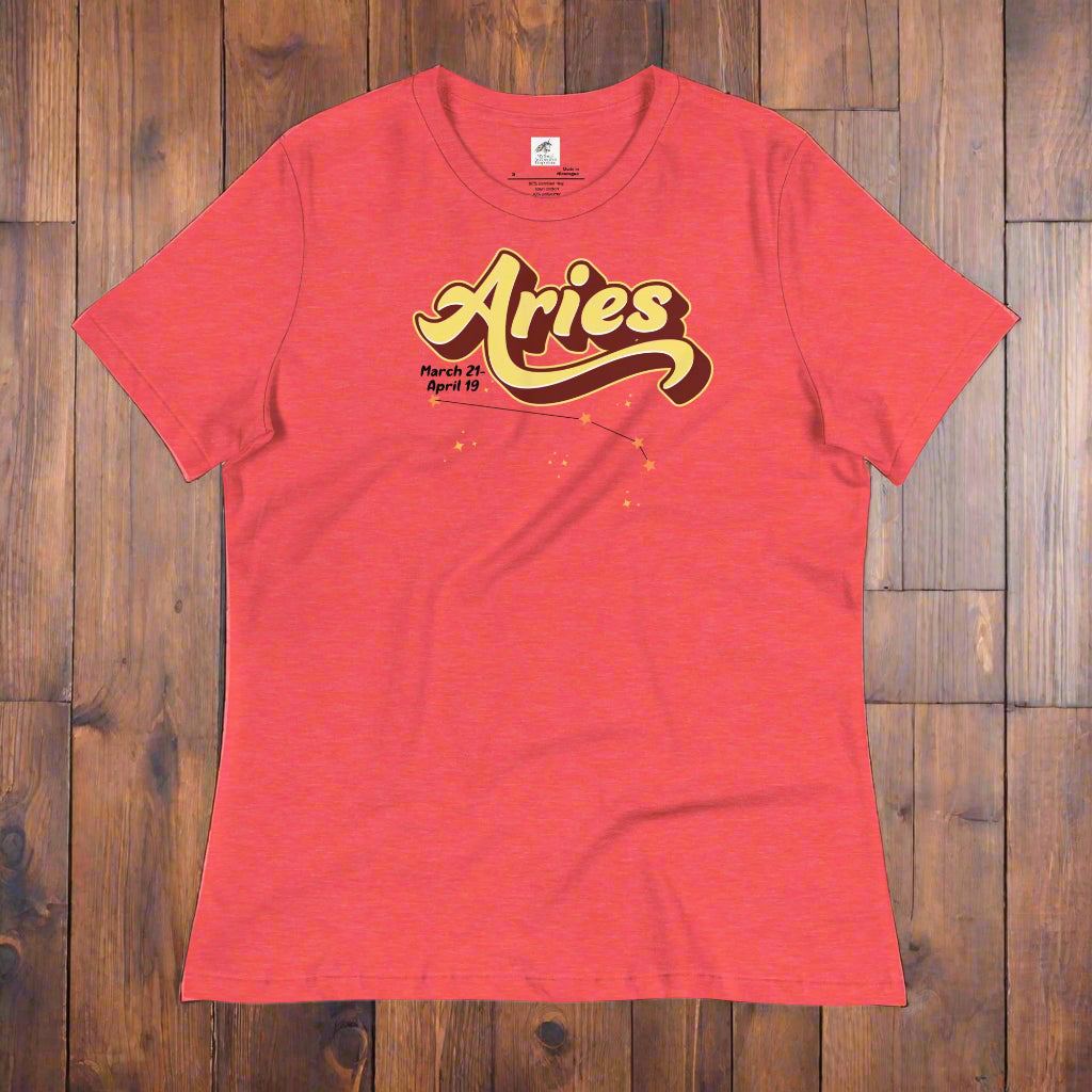 Aries Tee laying flat on a wooden counter, heather red astrology shirt. On the top is the word Aries in light yellow lined with maroon. Under the A are the dates March 21-April 19. Below his is the constellation Aries in bright yellow orange stars connected with a black line. Aries constellation zodiac astrology sign.