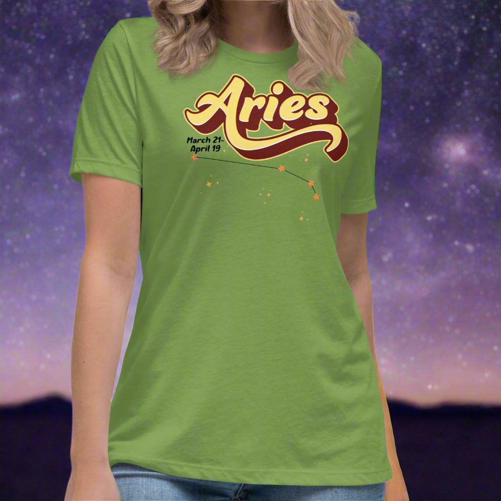Woman wearing a leaf green t-shirt facing forward. On the top is the word Aries in light yellow lined with maroon. Under the A are the dates March 21-April 19. Below his is the constellation Aries in bright yellow orange stars connected with a black line. Aries constellation zodiac astrology sign.