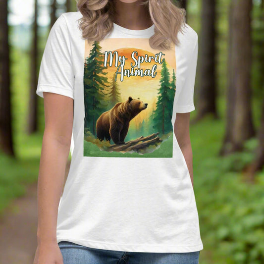 Women's My Spirit Animal Grizzly Bear T-Shirt. Front view white shirt. Grizzly Bear paused in front of logs walking through the forest framed in a sunset. My Spirit Animal at the top between fir trees.