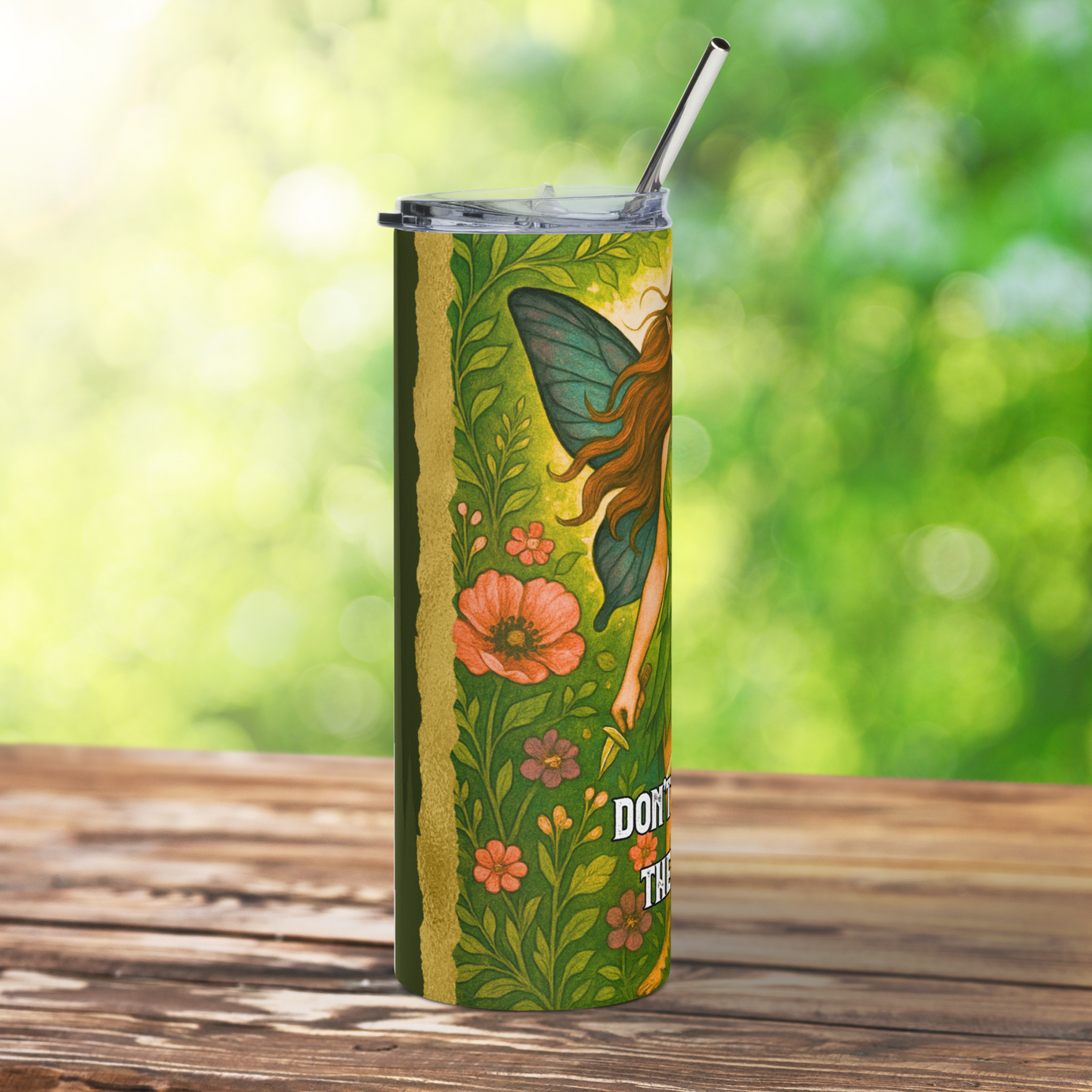 Stainless Steel Tumbler 20 oz. Left side view of the blue/green butterfly wing, left arm holding a pointed knife, and flowers. At the top you can see the metal straw sticking up out of the plastic BPA free lid. 