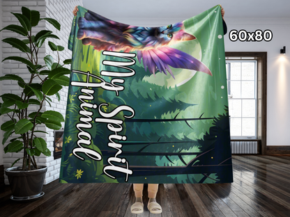 Lightweight Sherpa Throw Blanket 60x80" held up by model. Models hands are above her head with the blanket draped back and over by about 20% and the blanket reaches right below her knees. Longhaired Maine Coon Cat in Rainbow Fur with Fairy Wings in Rainbow colors. Fairy Cat is sitting in a moonlit forest with a full moon behind the cat. The background is in greens. The cat is pinks, purple, blue, yellow, and orange pastels.  Text on the blanket in white My Spirit Animal Fantasy Couch throw blanket