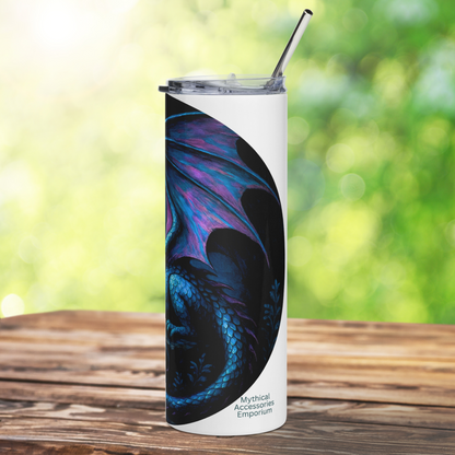 Insulated stainless steel fantasy dragon tumbler. This is a right side view of a blue dragon with purple highlights on the wings, horns, and tail. The dragon is resting on an outcrop of rocks at night. There is a dark cloudy sky with a full moon. Graphic is in blues and purple. You can see the stainless steel straw sticking up from the tumbler.  The graphic is on a white tumbler. 
