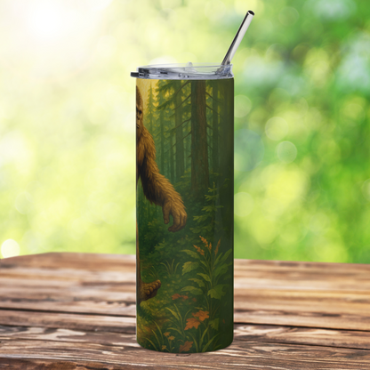 Bigfoot 20 oz stainless steel skinny tumbler with bpa free plastic lid and metal straw. This is the right side. You can see part of big foot's face, arm swinging to the front, and his foot. Background is old growth pine forest. Big Foot gifts