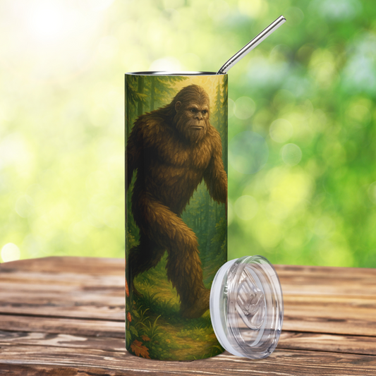 Stainless Steel Tumbler with metal straw sticking out of the top. The front view is big foot striding through old growth forest. He is furry, brown, and incredibly real looking, no touching. BPA free plastic lid is leaning against the water bottle on the right side. bigfoot merchandise