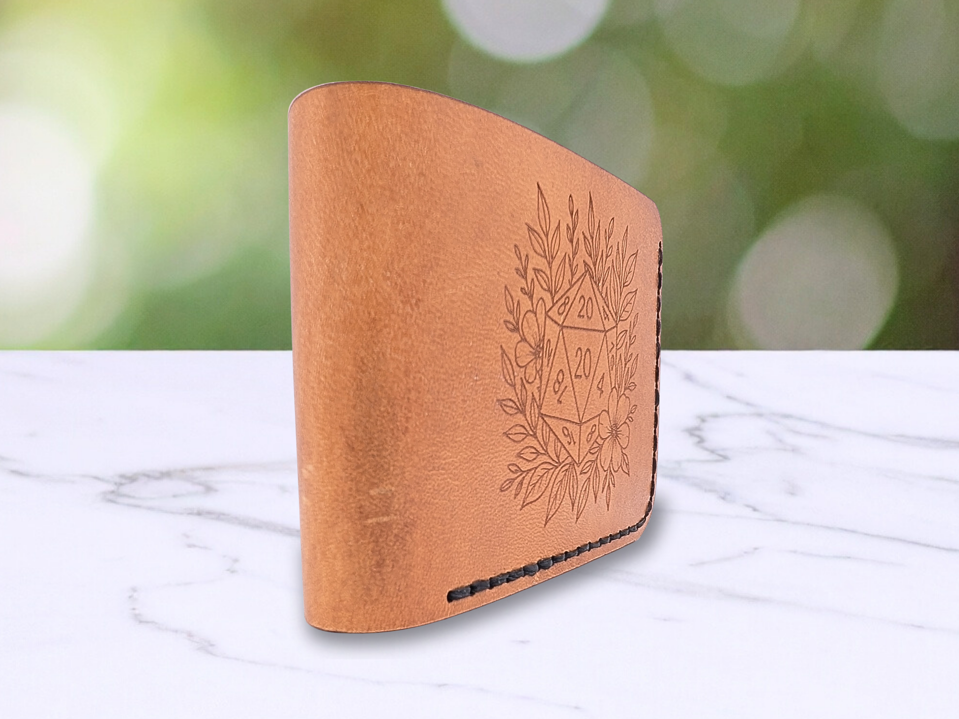 Leather Bi Fold D20 Handmade Wallet standing on it side. The view is from the folded edge of the wallet to let you see how it is folded, the color variations of the natural veg tan leather.