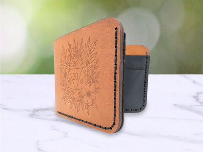 Veg Tan Leather Bi Fold wallet standing up. In this photo you see the front opening to the interior. You can see the D20 engraving, black hand stitching, and the dark edges of the wallet. You get a peak into the interior of the black card pockets. 