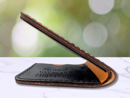 Leather Handmade Bi Fold Wallet. Folded edge view to see bottom edges of the wallet are dark. Bottom fold of the wallet shows the interior black leather card pockets with the Mythical Accessories Emporium engraved on the front of the card pocket.