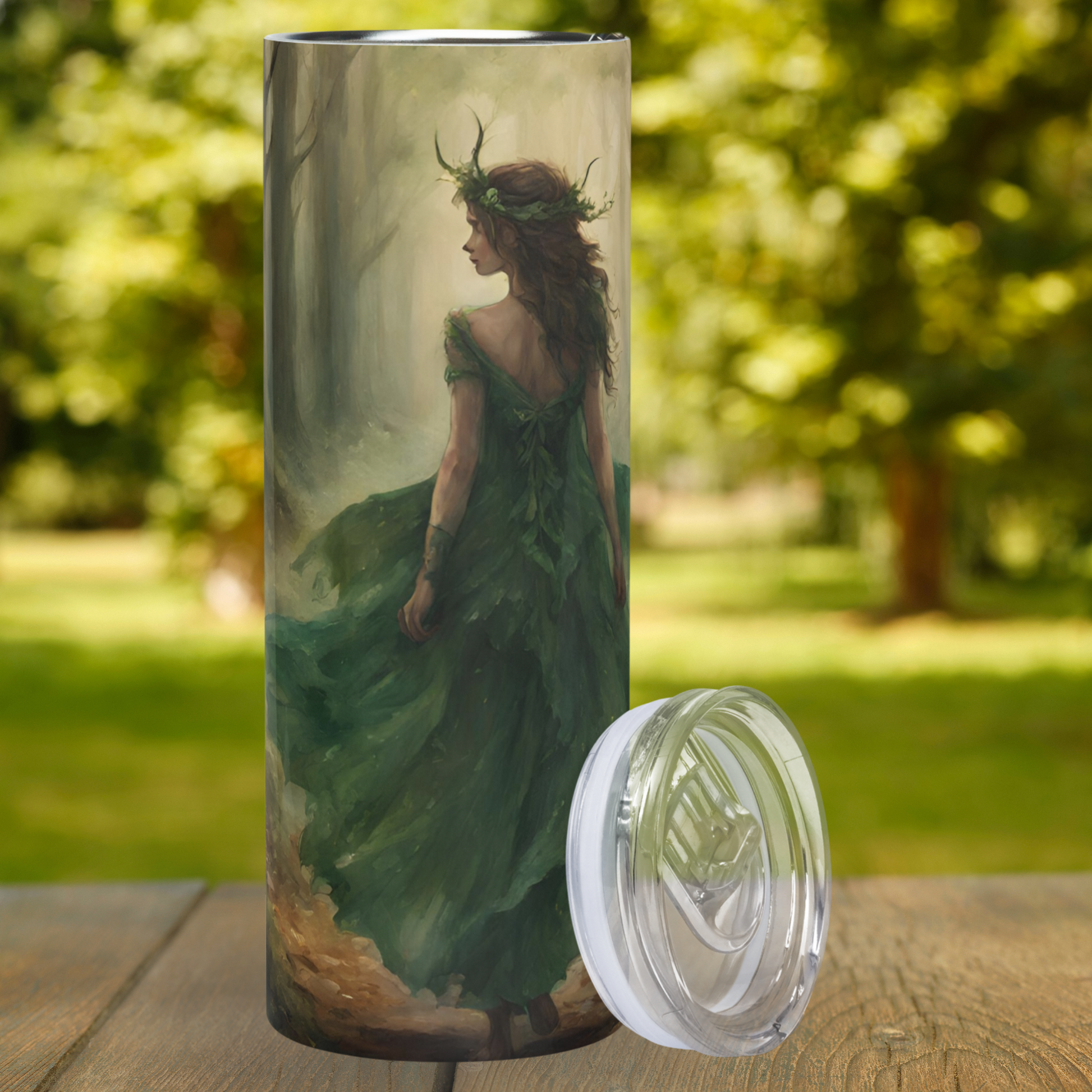  Elven Queen 20 oz Stainless Steel Tumbler front view. Fairy queen with a crown of green leaves and horns on her head. Long brown hair and green flowing dress walking through a dark wooded path with her back turned to the viewer. Ren Faire Coffee Tumbler