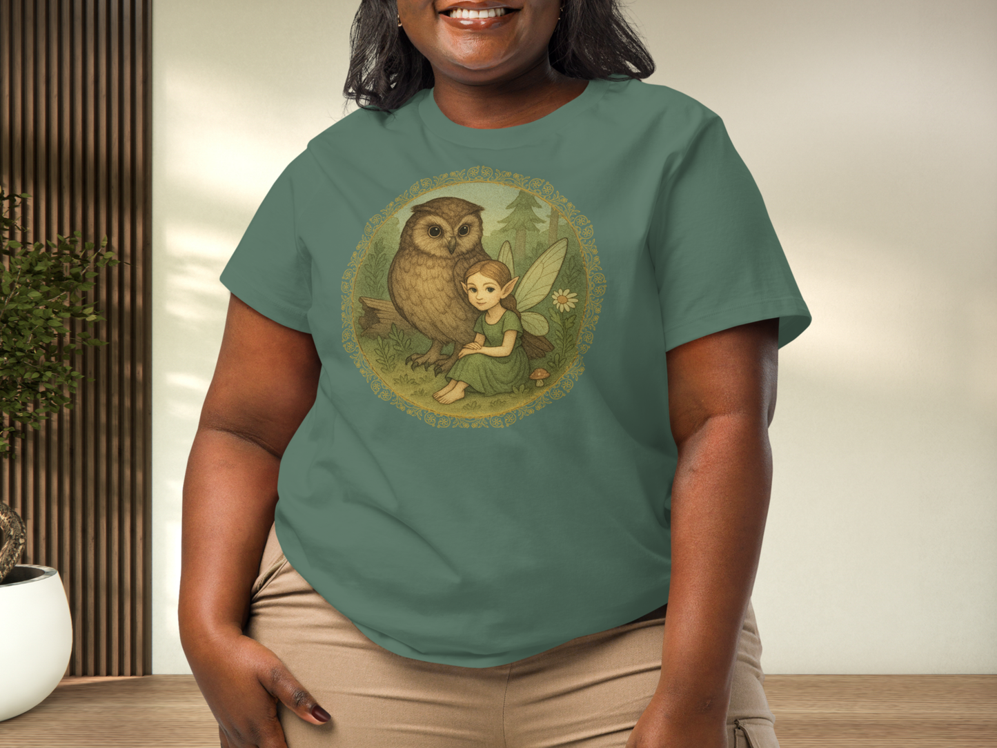 Person wearing a Bay Green Graphic t-shirt with an owl and fairy design. 